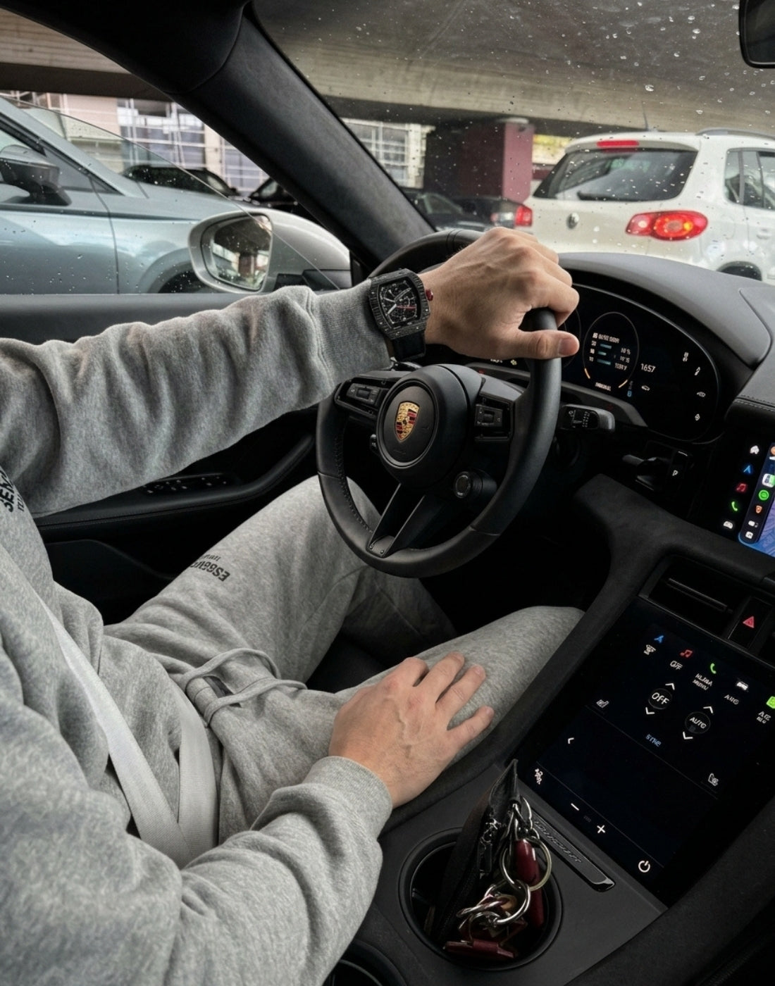 Relógio esportivo escuro no pulso de um motorista ao volante, em imagem da coleção Sport Fabbricantti.