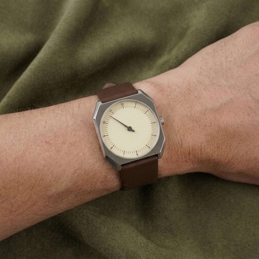 Rettrato 38mm Creme Fabbricantti no pulso em vista diagonal, com mostrador de ponteiro único e pulseira marrom.