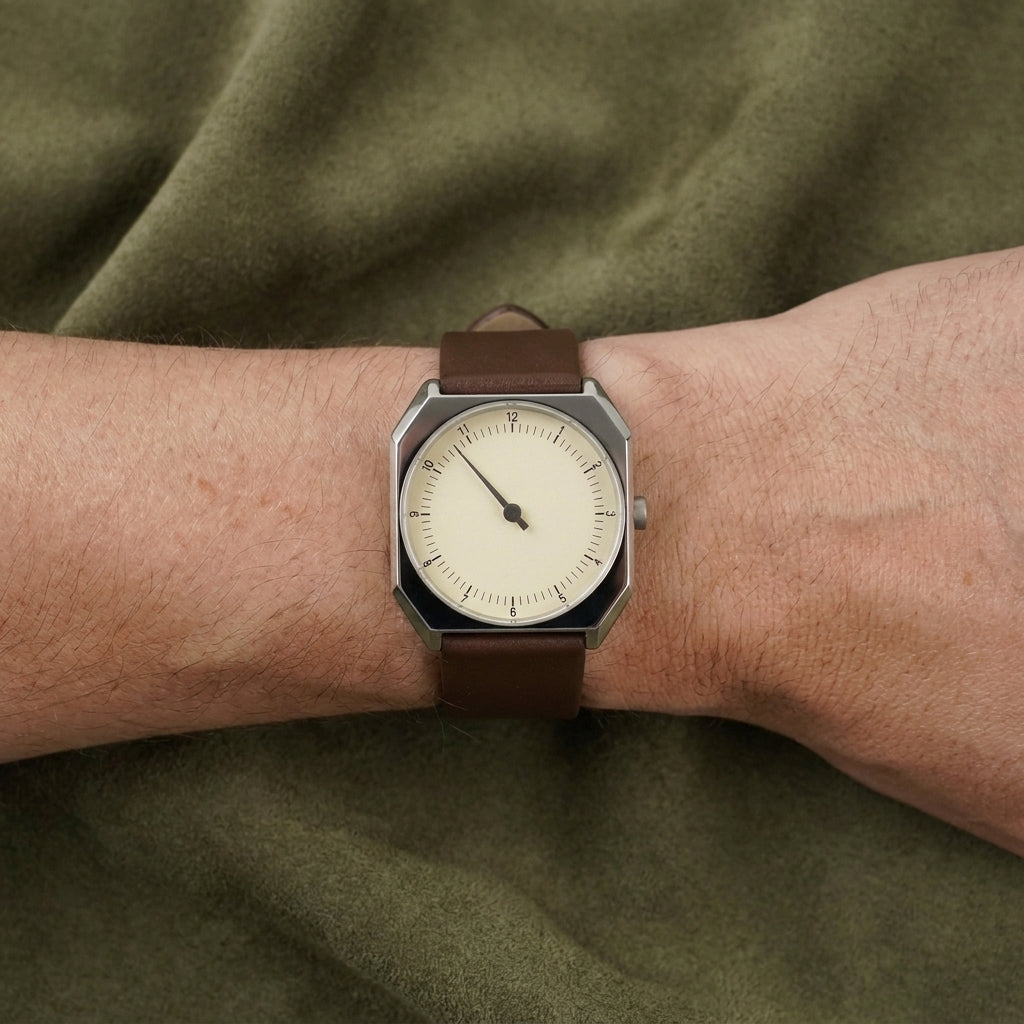 Relógio Rettrato 38mm Creme Fabbricantti no pulso, com caixa prateada e pulseira marrom, sobre tecido verde-oliva.