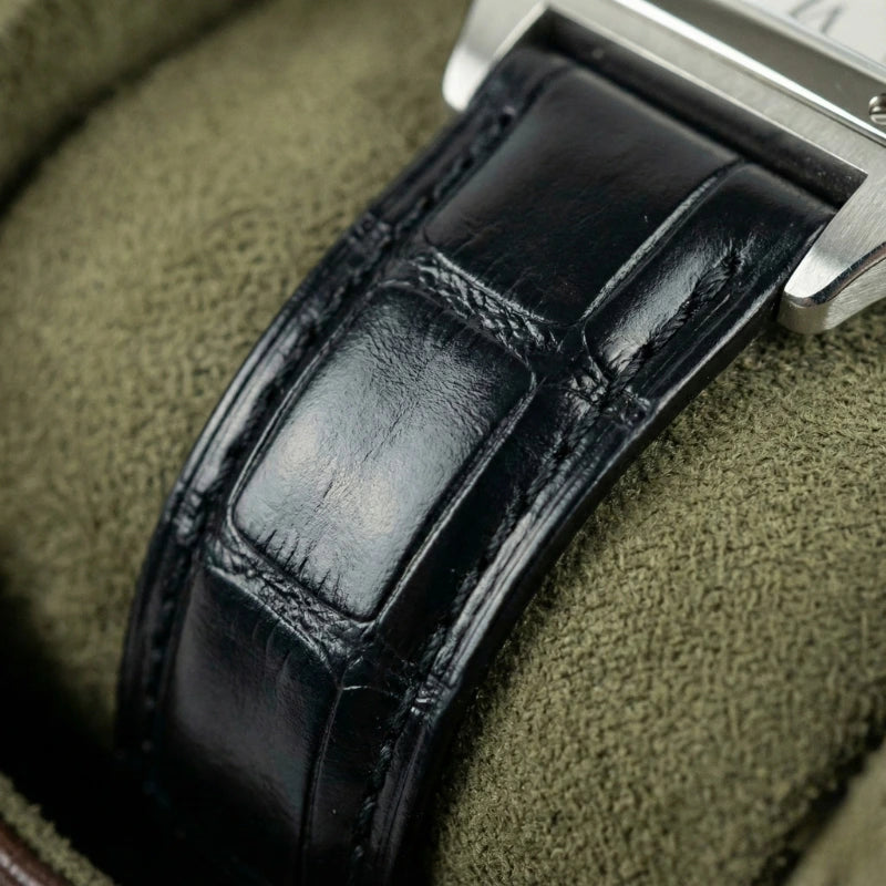 Fabricante relogio pulseira couro jacare preto fecho aço inoxidavel detalhe macro fundo tecido verde